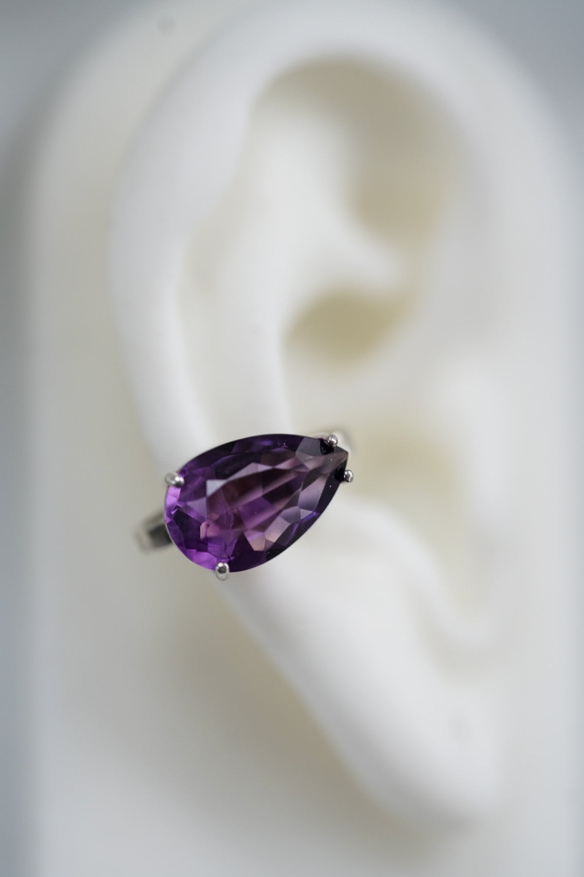 ear cuff in silver with a pear shaped amethyst 