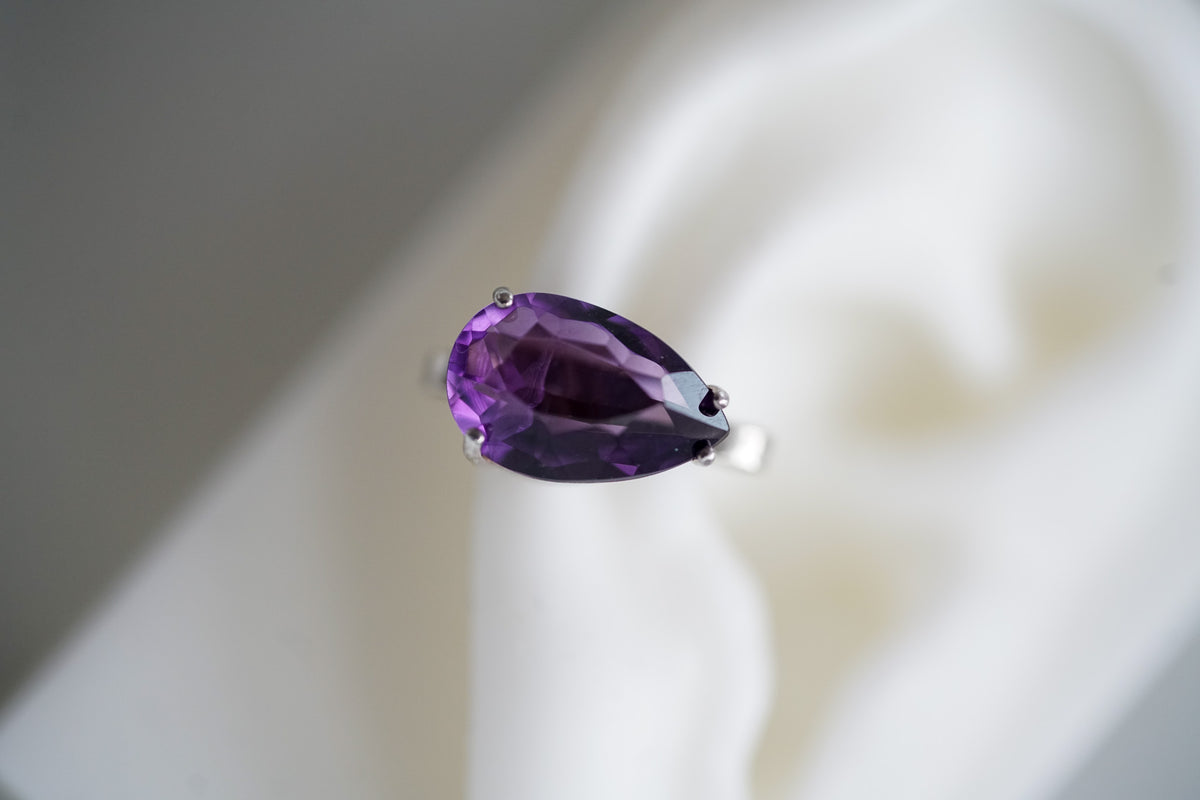 pear shaped amethyst ear cuff in silver on a ear lobe 